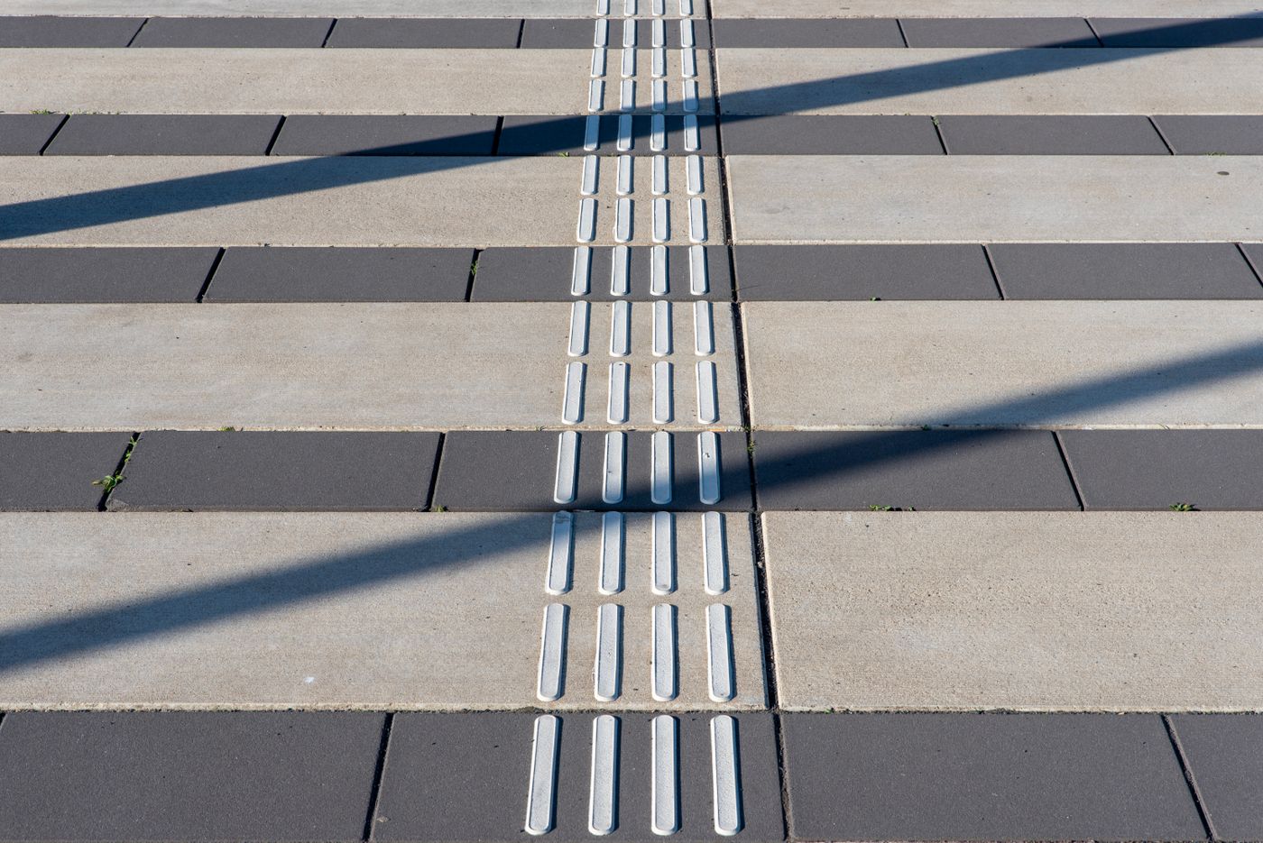 Tactile paving runs through a broad pedestrian walkway.